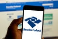 Logo of the Receita Federal do Brasil in the mobile device. Concept of income tax, economy, interest, taxes