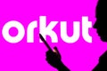 April 29, 2022, Brazil. In this photo illustration, the Orkut logo is seen in the background of a silhouetted woman holding a Royalty Free Stock Photo