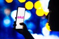 April 29, 2022, Brazil. In this photo illustration, a silhouetted woman holds a smartphone with the Orkut logo displayed on the Royalty Free Stock Photo