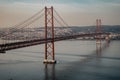 `25 of April` Bridge over tagus river at sunset in Lisbon, Portugal. View from Sanctuary of Christ the King `Cristo Rei