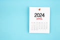 April 2024 calendar page with push pin on blue background Royalty Free Stock Photo