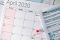 April 2020 calendar with the 15th pinned with tax day text, and 1040 tax forms