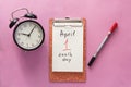 1 april fool's day, notebook, clock, pen. Flat lay on pink background Royalty Free Stock Photo