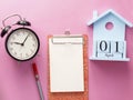 1 april fool's day wooden calender, notebook, clock, pen. Flat lay on pink background Royalty Free Stock Photo