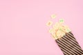 April Fools ' Day celebration background. Paper bag with many paper sheets with the words haha. 1 April mockup on pink background. Royalty Free Stock Photo