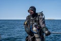 A scuba diver waiting for the dive boat to get into position so he can enter the water. Ocean and blue sky in the