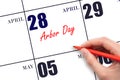 April 28. Hand writing text Arbor Day on calendar date. Save the date.