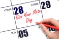 April 28. Hand writing text Kiss Your Mate Day on calendar date. Save the date.