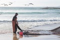 24 April 2023 Lisbon, Portugal: a fisherman pulls a fishing net out of the sea