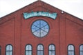 Louisville Slugger Field sign above round window set in brick building