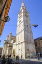 April 2022 Modena, Italy: Tower Ghirlandina of the Duomo Modena on the square piazza della Torre on a sunny day full of visitors