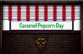 April month special day. Caramel Popcorn Day, Neon Text Effect on Bricks Background