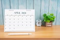 April Monthly desk calendar for 2024 year and alarm clock