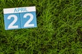 April 22nd. Day 22 of month, calendar on football green grass background. Spring time, empty space for text