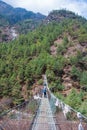 8 April 2018 - Nepal ::trekker cross the river by suspension bridge Royalty Free Stock Photo