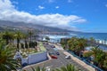 April 2018, Puerto de la Cruz, Canary Islands, Spain. City, beach with big waves, palm trees and a road with cars.