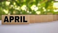 APRIL text on wooden block concept with blurry background