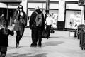 People shopping on Patrick Street in Cork, the main street for stores, street performers, restaurants; photographed in monochrome.