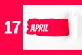 April 17th. Day 17 of month, Calendar date. Red Hole in the white paper with torn sides with calendar date. Spring month, day of