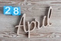 April 28th. Day 28 of month, daily calendar on wooden table background. Spring time theme