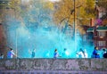 Holi - Color Run in Tulsa USA - Runners are squirted with colored powder on bridge with houses and trees