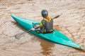 young athlete girl in a life jacket is engaged in water sports and paddles in his plastic canoe