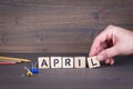 April. Wooden letters on the office desk, informative and communication background