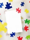April 2, World International Autism Day. White postcard on the background of colorful puzzles. The symbol and concert