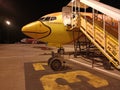 In the apron. The yellow plane in the airport is preparing for takeoff.