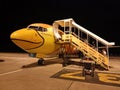 In the apron. The yellow plane in the airport is preparing for takeoff.