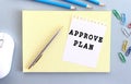 APROVE PLAN is written on a piece of paper that lies on a notebook. Royalty Free Stock Photo