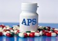 APS - medical acronym on a white jar against the background of randomly scattered tablets