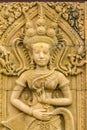 An Apsara dancing carved on the sandstone wall background. Apsara is a female spirit of the clouds and waters in Hindu culture. He