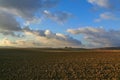 Between Apulia and Basilicata:hilly agricultural landscape before sunset.Farm on plowed land dominated by cloudscape view.Italy Royalty Free Stock Photo