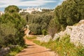 Apulian country road with stone walls and trulli in the background