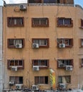 Aqaba, Jordan - January 21st, 2020: Air conditioning external units with large fans on old building facade wall near windows, many