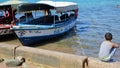 Colorful Glass boats along the beach with a little boy on the right side