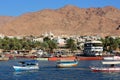 Glass boats on the Red Sea coast with the town of Aqaba and mountains in the background