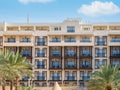 MÃÂ¶venpick Aqaba luxury hotel apartment building surrounded by palm trees Royalty Free Stock Photo