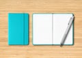 Aqua blue closed and open lined notebooks with a pen on wooden background Royalty Free Stock Photo