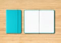 Aqua blue closed and open lined notebooks on wooden background Royalty Free Stock Photo