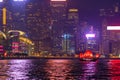 The Aqua Luna sailing in Hong Kong Downtown with skyscraper buildings. financial district in urban city at night. The red boat or