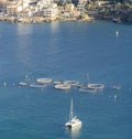 Aquaculture in Action: Fish Farm Circles and a Sailboat near a Coastal Village