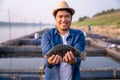 Aquaculture farmer hold quality tilapia yields in hand, guaranteeing integrity in organic bio-aquaculture. Fish is a high-quality