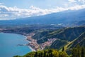 Aquamarine blue waters of Mediterranean sea near Taormina resorts and Etna volcano mount in Sicily, Italy. Shiny summer day,