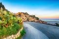 Aquamarine blue waters of  sea and fantastic cityscape of Taormina during sunset Royalty Free Stock Photo