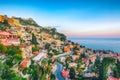 Aquamarine blue waters of  sea and fantastic cityscape of Taormina during sunset Royalty Free Stock Photo