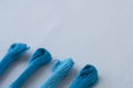 Aquamarine embroidery threads on white canvas. Place for text. Macro Royalty Free Stock Photo
