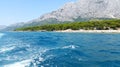 Aquamarine water of Adriatic sea in Middle Dalmatia and light gray mountains