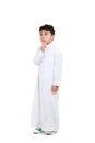 Arab boy with a confused look and his hand on chin, looking up, wearing white traditional Saudi Thobe and sneakers, raising his